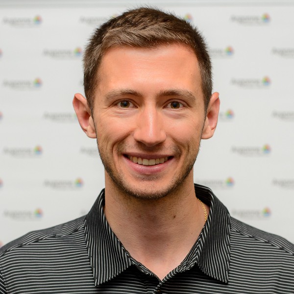 Mike Pajkos smiling in a striped black and white button down.